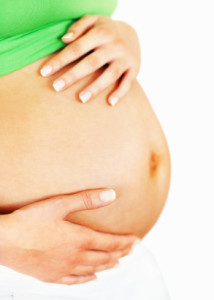 Pregnant woman on white background with a closeup midsection of her belly